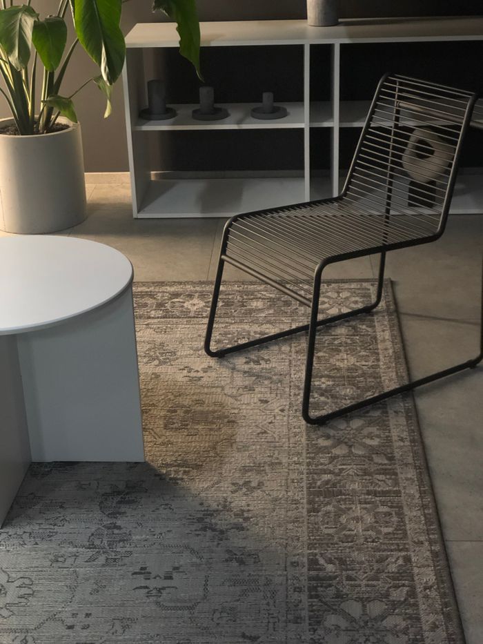 Home Stylish living room featuring a metal chair, round coffee table, and decorative rug in a modern setting.